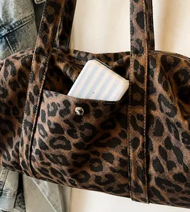 Detailed close-up of leopard print tote bag featuring a durable front pocket with metal buckle