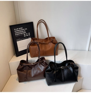 Detailed trio of PU leather tote bags in brown and black on minimalist white display steps