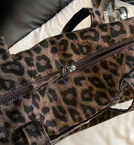 Detailed close-up of the smooth metal zipper on this leopard print fabric tote bag