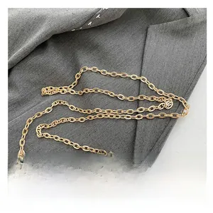 Detail of elegant gold-tone chain strap and spherical lock on a stylish evening bag
