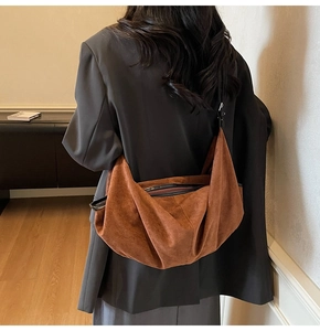 Brown suede tote bag shown on shoulder featuring soft texture and large capacity