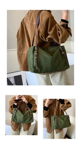 Detail view of olive suede shoulder bag featuring adjustable brown leather strap and gold buckle