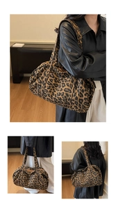 Detail of large leopard print tote bag showing cylinder shape and silver metal buckle