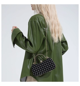 Close-up of polka dot evening bag with gold handle and rhinestone clasp decoration