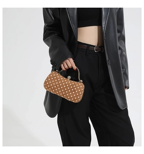 Detailed close-up of a retro brown polka dot box bag with gold handle and crystal clasp