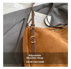 Detail view of adjustable dark brown faux leather shoulder strap with gold metal buckles