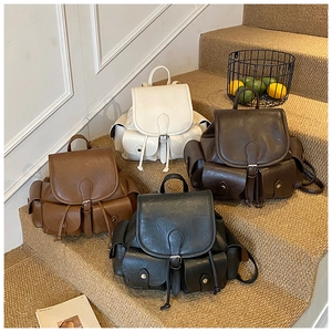 Retro student backpacks in multiple colors displayed on steps with lifestyle decor