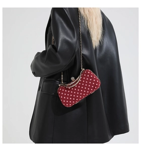 Detail of red polka dot velvet handbag with gold diamond-encrusted clasp and chain