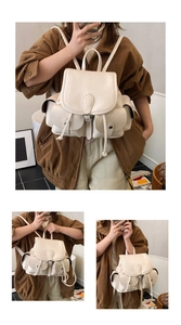 Detail view of the cream pleated backpack featuring functional multi-pockets and leather texture