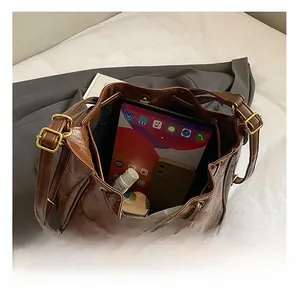 Interior of brown quilted leather bucket bag showing storage space for tablet and makeup