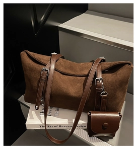 Detail view of large brown suede tote bag with matching leather strap and mini pouch