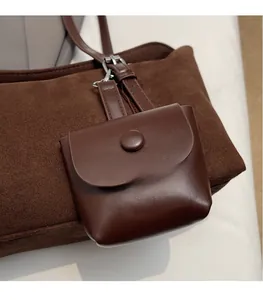 Close-up of chocolate brown faux leather mini pouch accessory with matte texture on tote bag