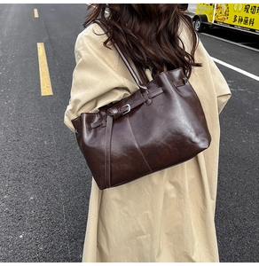 Détail du grand sac cabas en cuir marron foncé avec boucle latérale et texture vintage
