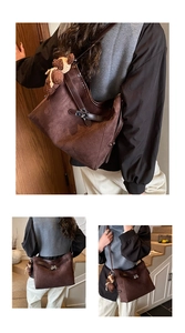 Detail of dark brown matte leather tote with metal turn-lock and cute bear charm