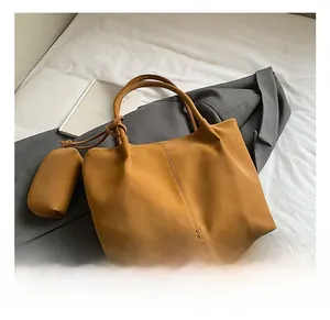 Detail view of large caramel brown tote bag with smooth texture and matching pouch