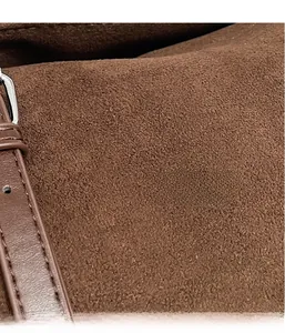 Macro shot of brown frosted suede texture with neat stitching and silver metal buckle
