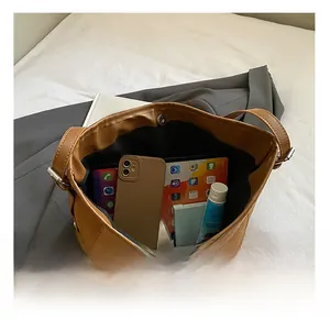 Interior view showing the large capacity and magnetic buckle of this brown leather tote bag