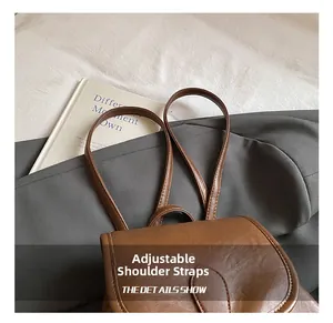 Detail view of adjustable slender shoulder straps on a vintage brown leather backpack