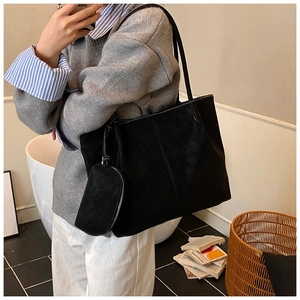 Detail of minimalist black matte suede tote bag with matching hanging coin pouch