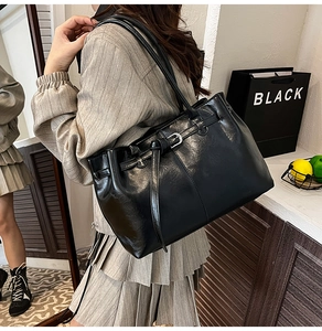 Détail du grand sac cabas noir rétro avec boucles métalliques et cuir brillant lisse