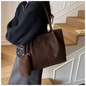 Detail of dark brown faux leather tote bag with vertical stitching and side coin purse