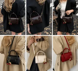 Detailed view of vintage small square bags in four colors with cherry charms and straps