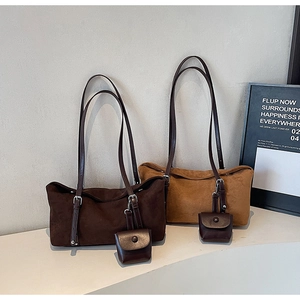 Close-up of minimalist denim-style tote bags with metal buckles and mini pendant pouches