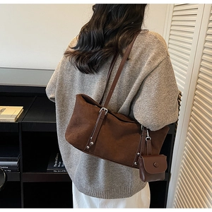 Detail of dark coffee suede tote bag with detachable pouch and long shoulder straps