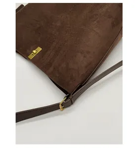 Detail view of vintage dark brown suede tote with elegant gold rectangular twist lock