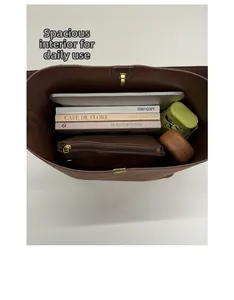 Interior view of brown leather bucket bag showing capacity for tablet, books, and umbrella