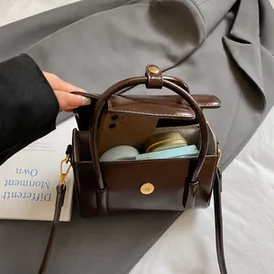 Detail showing internal capacity of the brown vintage square handbag with daily essentials