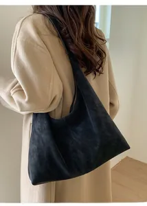 Detail view of large black suede tote bag shown on model for a casual commute look