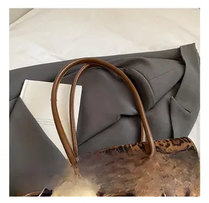 Gros plan détaillé du sac léopard avec poignée en cuir marron et boucle métallique chic