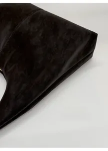 Detailed macro view of dark brown faux suede material and stitching on the tote bag