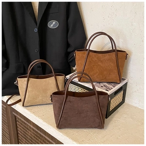 Drei Wildleder-Einkaufstaschen in Beige, Hellbraun und Dunkelbraun auf Steinfläche