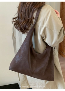 Detail of dark brown faux suede hobo bag shown on model with retro minimalist aesthetic