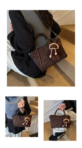 Detail der Vintage-Tragetasche aus Wildleder mit Lederbesatz und Bärenanhänger