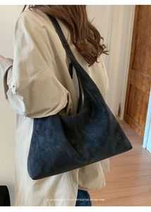 Minimalist black suede hobo bag shown on shoulder for daily commute style