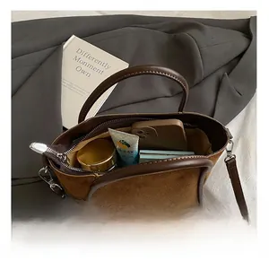 Draufsicht auf das Innere der braunen Wildledertasche mit Platz für Handy und Kosmetik