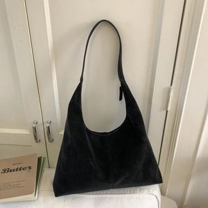 Detail of minimalist black faux suede hobo bag with high-capacity interior and soft texture