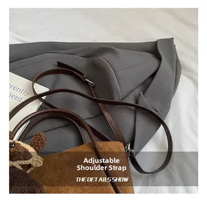Detailansicht einer braunen Wildleder-Beuteltasche mit Lederriemen und Plüsch-Anhänger