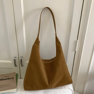 Detail of camel hobo bag showing matte suede texture and flat shoulder strap design