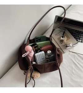 Brown suede tote bag showing spacious interior with laptop, umbrella, and accessories