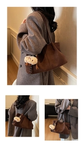 Detail view of brown suede tote bag with a white lamb wool pendant on a wool coat