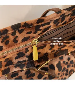 Macro view of golden metal zipper and leopard print fabric on large tote bag