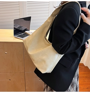 Détail d'un grand sac cabas en cuir beige pour le bureau avec texture souple et large bandoulière