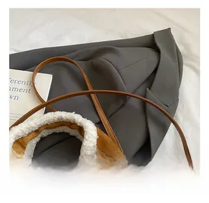 Détail de la bordure en fausse fourrure sur un sac seau en daim marron avec sangle