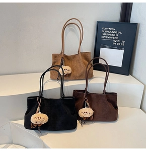 Three colors of suede tote bags with cute plush charms on a minimalist display