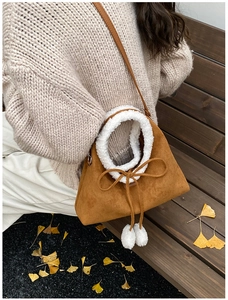 Close-up of vintage brown suede handbag with white faux fur trim and bow detail