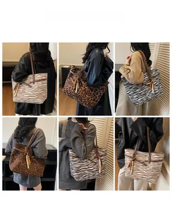 Detail view of large faux suede tote bags with zebra and leopard prints and fringe charms